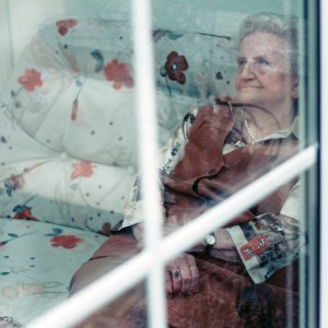 Eine alte Frau sitzt auf dem Sofa: Wer heute noch unabhängig zu handeln vermag, kann schon morgen durch Pflegebedürftigkeit eingeschränkt sein.  Bild: Kay Fochtmann, photocase.com