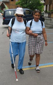 Ferienwoche des SZB: Eine freiwillig Begleiterin führt eine blinde Person. Bild: UCBA