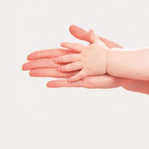 Das Bild zeigt zwei Hände ineinander – eine erwachsene Hand berührt die Hand eines Kindes. Bild: Laboko / Shutterstock.com