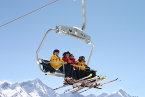 La photo montre des skieurs sur un télésiège. 