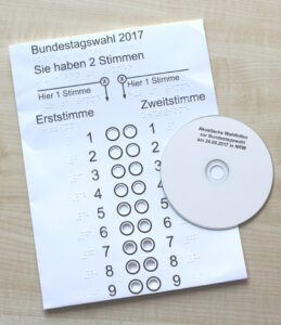 Das Bild zeigt die Wahlschablone und die CD auf einem Tisch liegend.
