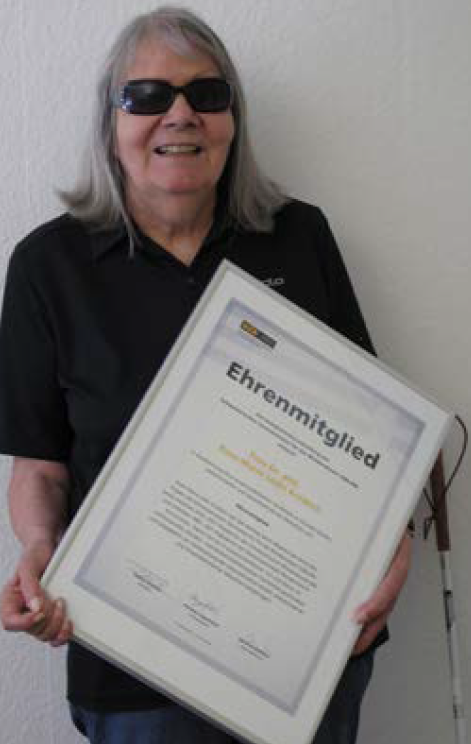 Dr. Rose-Marie Lüthi-Kreibich hält die Ehrenmitglied-Urkunde in der Hand.
