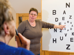 La photo montre Susanne Trefzer et une cliente devant un tableau de vision. 