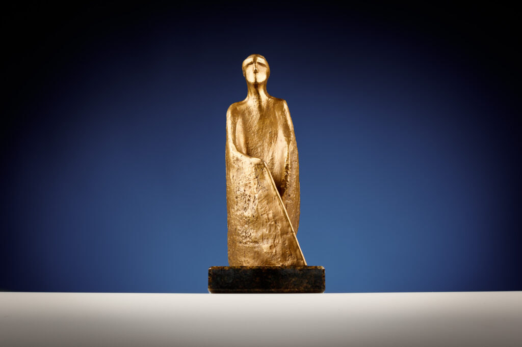 Die Staute des Prix de la Canne blanche zeigt eine sehbehinderte Person, die einen weissen Stock in der Hand hält. Die Statue ist aus Bronze. 