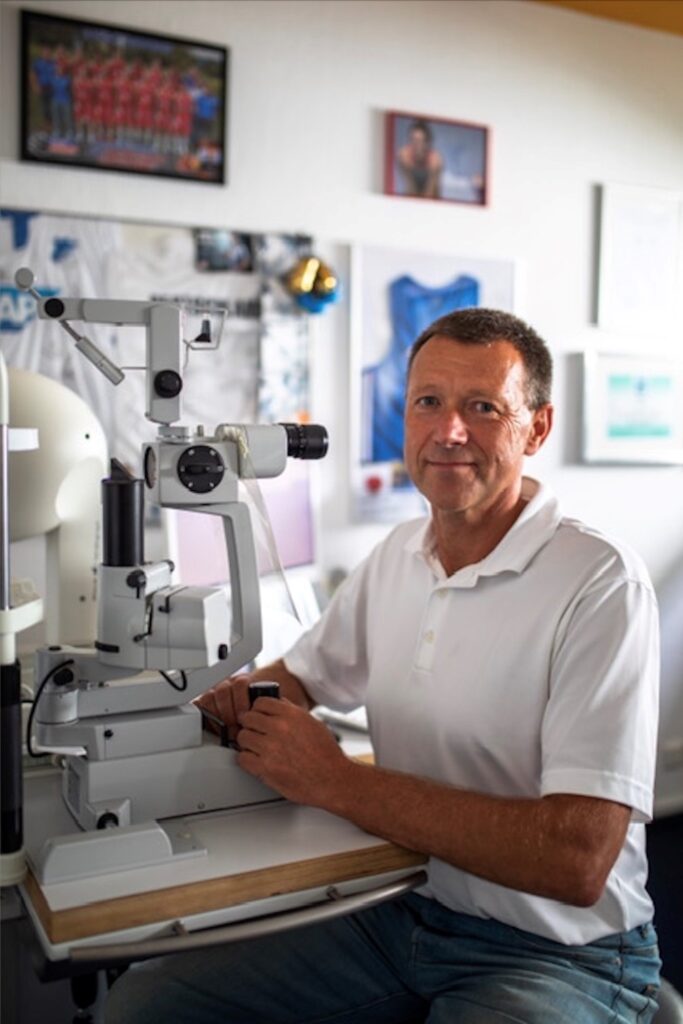Dr. Thomas Katlun sitzt vor einem Apparat zur Untersuchung der Augen. 